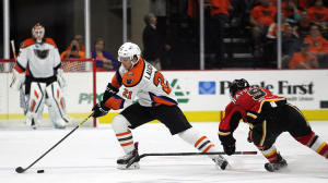 Phantoms Center Scott Laughton (21) steals the puck from Flames Forward Garnet Hathaway (9) during second period action Friday at the PPL Center in Allentown. [photo: Chris Knight]