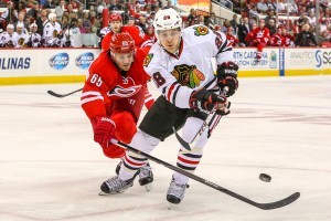 Chicago Blackhawks right wing Ben Smith (28) and Carolina Hurricanes defenseman Ron Hainsey (65)   - Photo Credit:  Andy Martin Jr