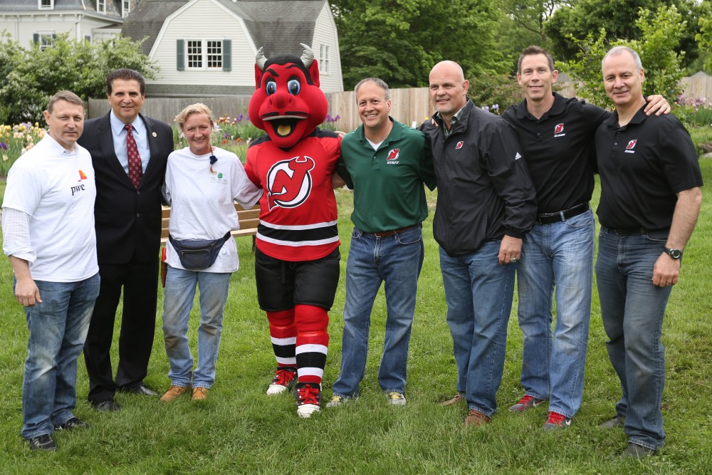 (L-R) Ed Heitin, PwC Partner and New York Metro Green Team Leader; Joseph N. DiVincenzo, Jr., Essex County Executive; Lisa Simms, Executive Director of the New Jersey Tree Foundation; Jim Leonard, Senior Vice President of Community Investment, Devils Arena Entertainment; and Devils alumni Ken Daneyko, Grant Marshall and Bruce Driver join NJ Devil at Presby Memorial Iris Gardens in Upper Montclair, New Jersey for today’s tree planting event as part of the “Pucks for Parks” initiative. (Kerry Graue / New Jersey Devils)