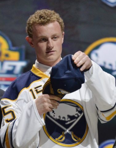 Jack Eichel putting on Sabres cap after being drafted.