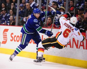 Ronalds Kenins carries through with a massive bodycheck on Calgary's Dennis Wideman. (Anne-Marie Sorvin-USA TODAY Sports)