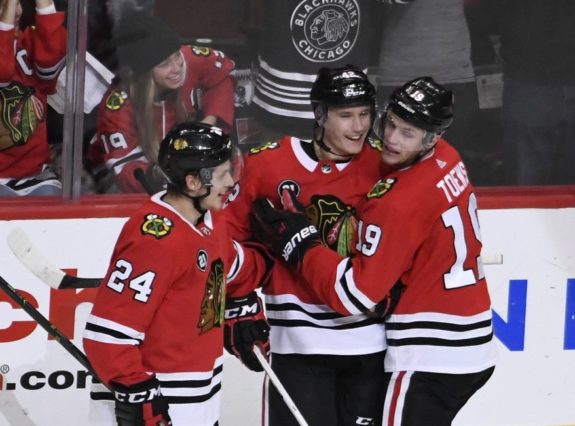 Chicago Blackhawks Gustav Forsling, center, celebrates with Dominik Kahun and Jonathan Toews