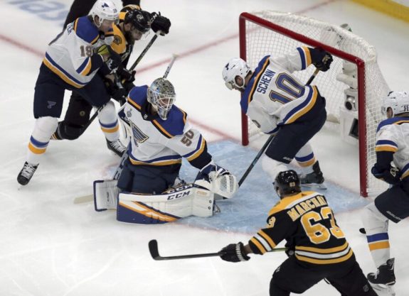 Patrice Bergeron and Brad Marchand battle in front of the Blues net.