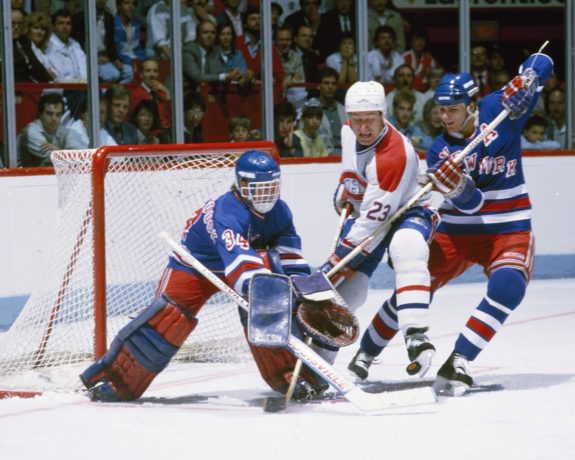 John Vanbiesbrouck pokes the puck away from Bob Gainey