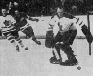 Johnny Bower handled this play in the first period, then went behind the Toronto bench in the third/