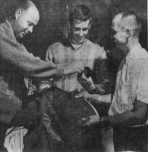 Nashville captain Lloyd Hinchberger, left and goalie Marv Edwards, right, help rookie Ron Hindson with his new uniform.