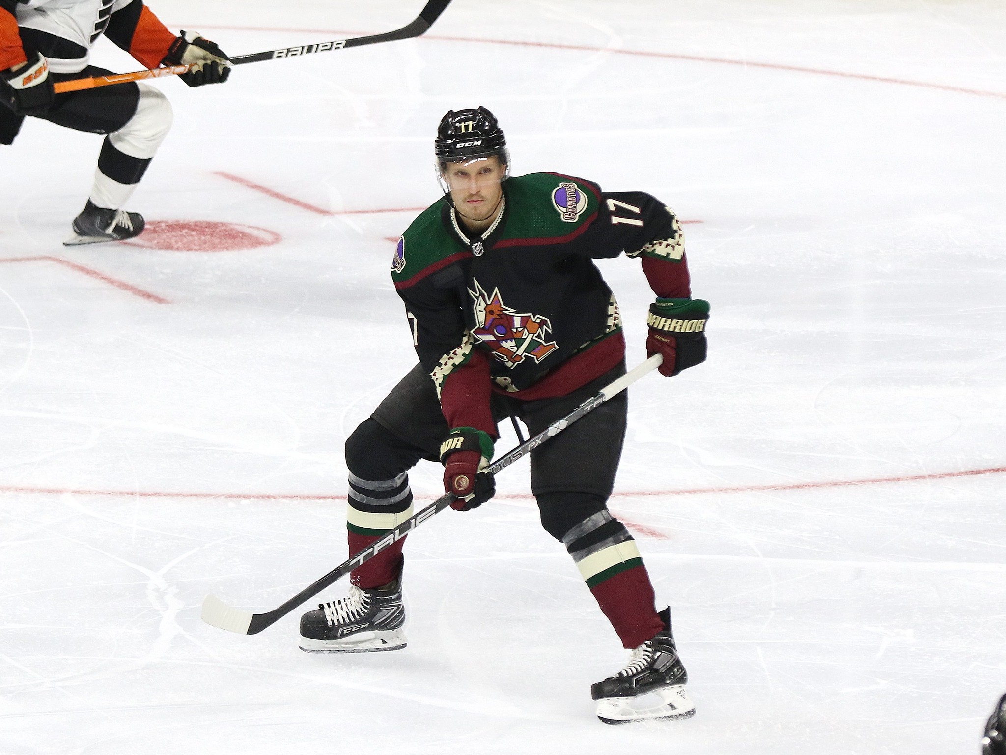 Arizona Coyotes center Nick Bjugstad (17) gets the puck away from Ottawa  Senators left wing Tim Stützle (18) during the second period of an NHL  hockey game in Tempe, Ariz., Thursday, Jan.